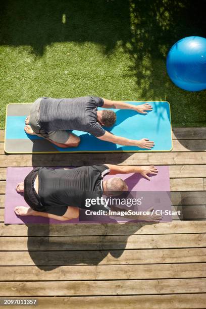 mature couple practicing yoga in back yard - gray shorts stock pictures, royalty-free photos & images