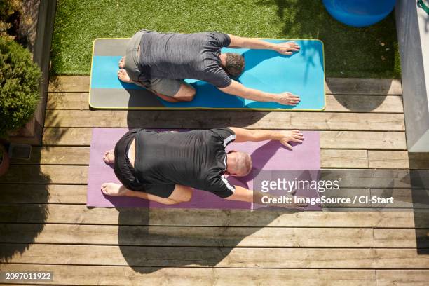 mature couple practicing yoga in back yard - gray shorts stock pictures, royalty-free photos & images