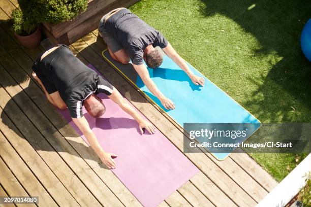 mature couple practicing yoga in back yard - gray shorts stock pictures, royalty-free photos & images