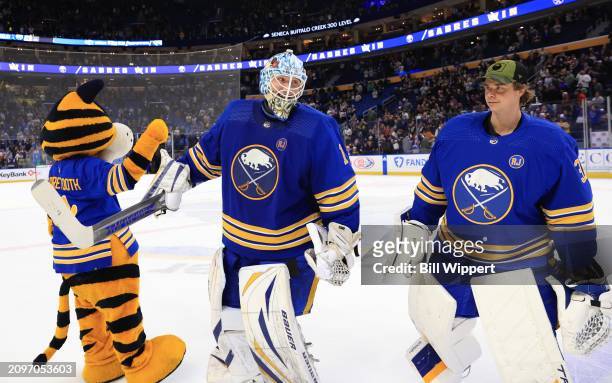 Ukko-Pekka Luukkonen of the Buffalo Sabres celebrates a win following an NHL game against the New York Islanders with mascot Sabretooth and Eric...