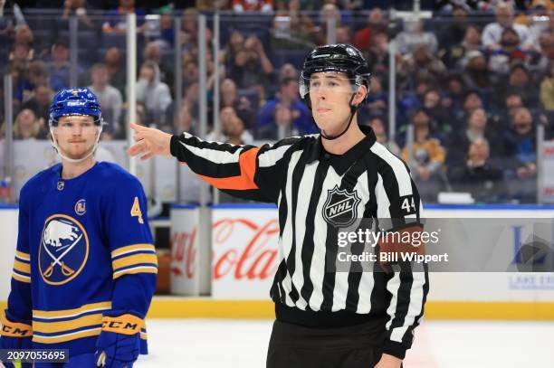 Referee Justin Kea gestures alongside Bowen Byram of the Buffalo Sabres during an NHL game with the New York Islanders on March 14, 2024 at KeyBank...