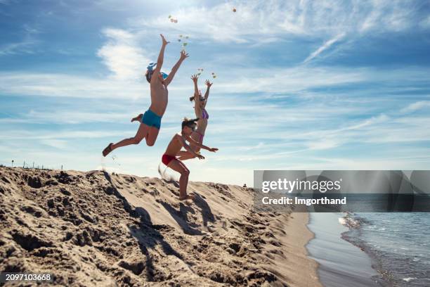 three kids playing with easter eggs on the beach. - easter beach stockfoto's en -beelden