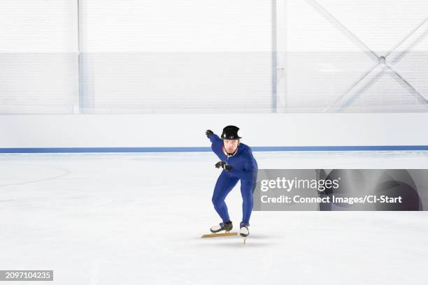 young man practicing speed skating at ice rink - skater stock pictures, royalty-free photos & images