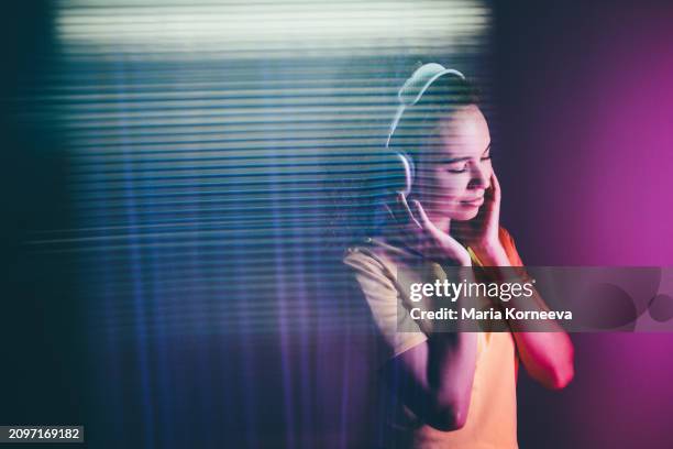 young woman listening to music on neon background. - musica imagens e fotografias de stock