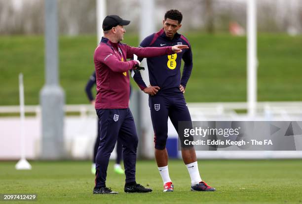 Steve Holland, Assistant Manager of England, talks to Jude Bellingham of England during a training session at St George's Park on March 19, 2024 in...