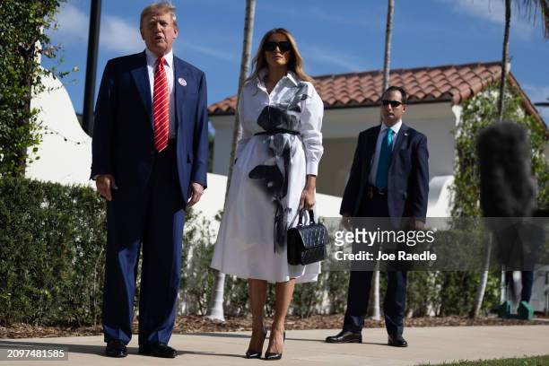 Former U.S. President Donald Trump and former first lady Melania Trump stand together as he speaks with the media after voting at a polling station...