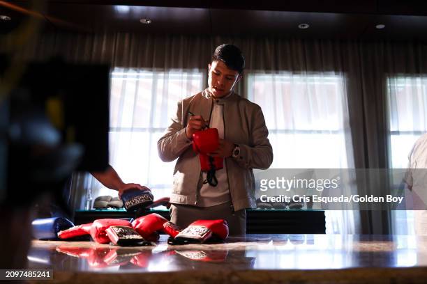 Jaime Munguia signs gloves at the Canelo Álvarez v. Jaime Munguía kickoff presser at The Beverly Hills Hotel on March 19, 2024 in Beverly Hills,...