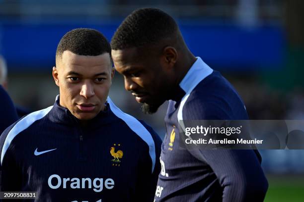 Marcus Thuram, speaks with Kylian Mbappe as they arrive for a France training session as part of the French national team's preparation for upcoming...