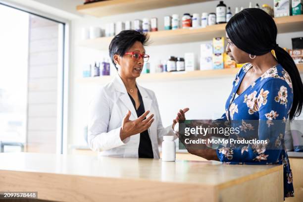 female doctor discussing supplements with woman in medical office - antioxidant support stock pictures, royalty-free photos & images