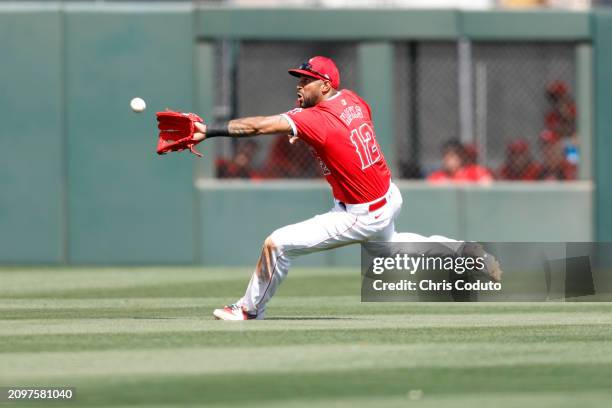 Aaron Hicks of the Los Angeles Angels makes a diving catch during the fourth inning of a spring training game against the Cincinnati Reds at Tempe...