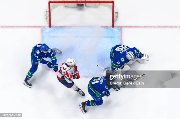 Casey DeSmith Pius Suter and Nikita Zadorov of the Vancouver Canucks defend against Tom Wilson of the Washington Capitals during the first period of...