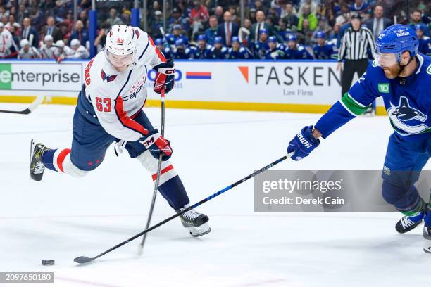 Ivan Miroshnichenko of the Washington Capitals is checked by Ian Cole of the Vancouver Canucks during the first period of their NHL game at Rogers...