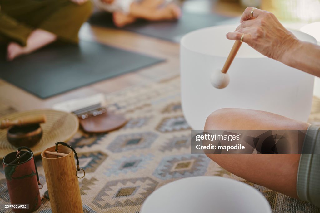 Yoga instructor with rin gongs leading a women's class at a wellnes retreat