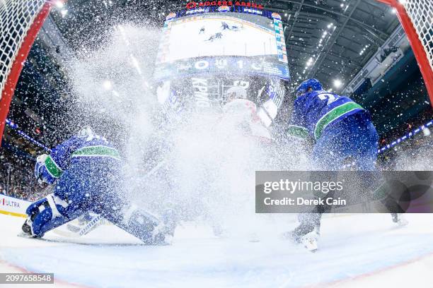 Casey DeSmith and Pius Suter of the Vancouver Canucks defend against Tom Wilson of the Washington Capitals during the first period of their NHL game...