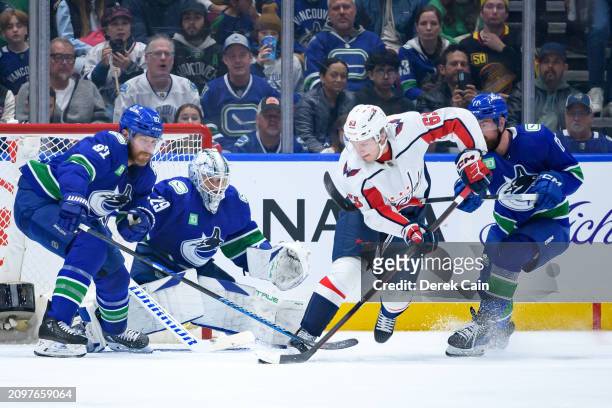 Ian Cole Casey DeSmith and Filip Hronek of the Vancouver Canucks defend against Ivan Miroshnichenko of the Washington Capitals during the second...