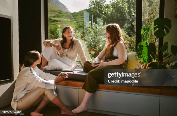 diverse group of women talking by a window during a wellness retreat - exercise room stock pictures, royalty-free photos & images