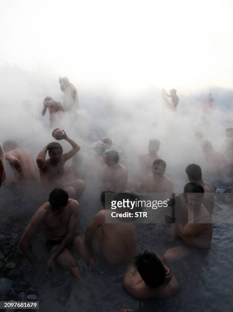 Hindu devotees take a holy dip in a natural hot water spring on the bank of the Satluj river on the occasion of the Makar Sankranti festival in...