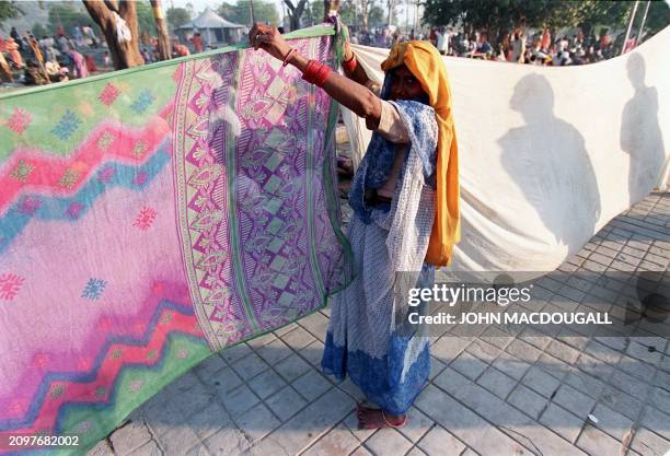 Hindu devotee dries her sari after bathing in India's most sacred river the Ganges during the climax of the Mahakumb festival 14 April, touted as one...