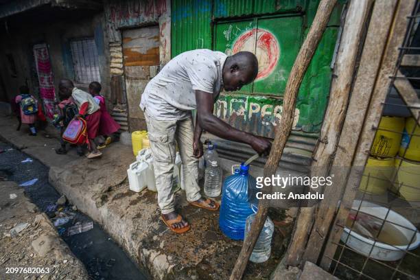 Kenyans living in the Mathare Valley slum fill empty jerry cans with water from the fountain on the eve of 'World Water Day' in Nairobi, Kenya on...