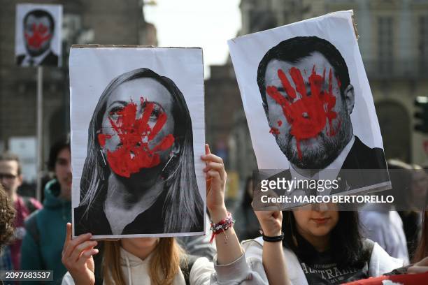 Students hold portraits of Italy's Prime Minister Giorgia Meloni and Italy's deputy Prime Minister Matteo Salvini with a red hand painted, during a...