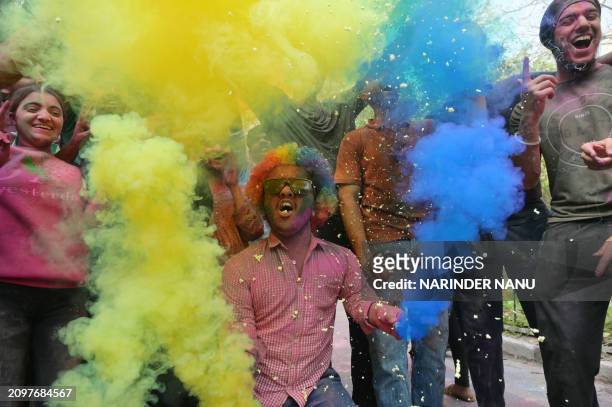 Students daubed in coloured powders celebrate the Hindu spring festival of 'Holi' at a university in Amritsar on March 22, 2024.