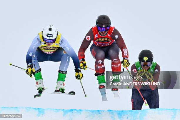 Italy's Simone Deromedis , Canada's Reece Howden and Canada's Jared Schmidt compete in the men's semi-final heat 1 of the ski cross event of the FIS...