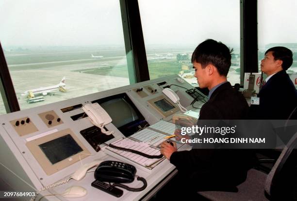 Vietnam Airlines' technicians work at Hanoi's airport flight control center on 29 December 1999. Although the National flag carrier Vietnam Airlines...