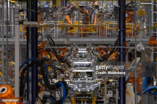 Robotic arms weld the body of a Mini Countryman at the bodyshop in the BMW Group factory in Leipzig, Germany, on Thursday, March 21, 2024....
