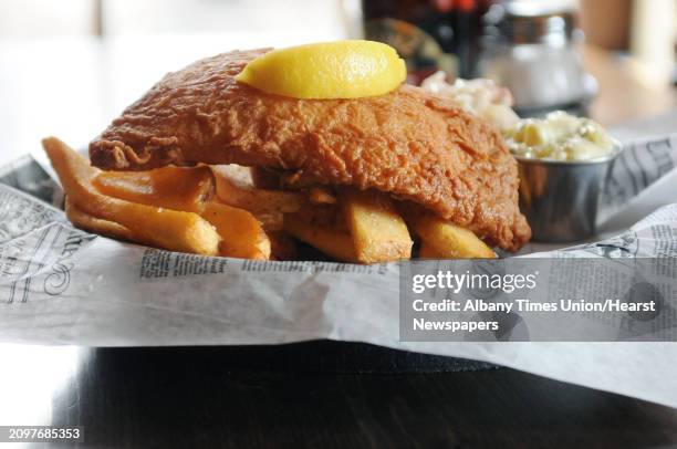 Fish and chips dish with fresh haddock delivered daily breaded in a house made batter served with home made coleslaw and tarter sauce at the Olde...