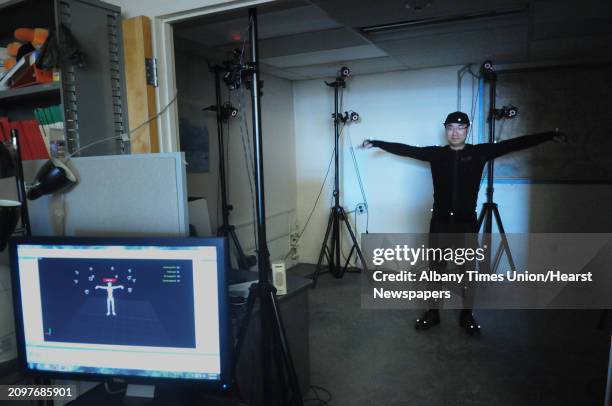 Doctoral student, Yiming Gao wears a motion capture suit in a room as an array of 12 3D motion capture cameras with infrared LEDs capture his...