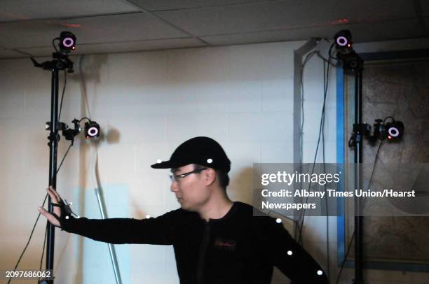 Doctoral student, Yiming Gao wears a motion capture suit in a room as an array of 12 3D motion capture cameras with infrared LEDs capture his...