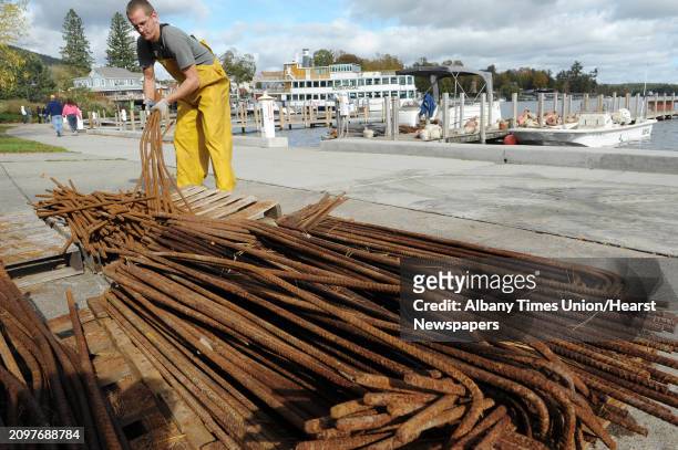 Kurt Bramer a diver with Aquatic Invasive Management gathers up some rebar to carry to a boat on Monday, Oct. 8, 2012 in Lake George, NY. Crews with...