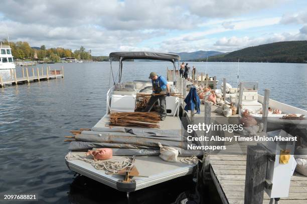 Kyle Jaquis, left, a diver with Aquatic Invasive Management loads some rebar onto a boat on Monday, Oct. 8, 2012 in Lake George, NY. Crews with the...