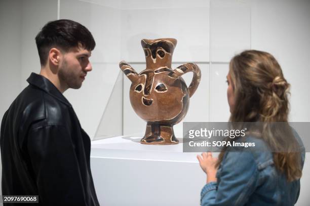 Visitors are seen looking at the sculpture "Buho con cabeza de fauno" by Pablo Picasso during the inauguration of the "Pablo Picasso: structure of...