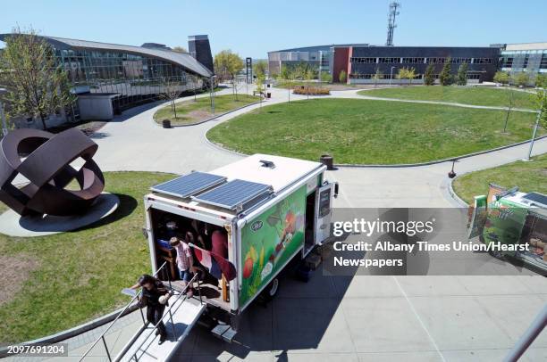 People exit the Veggie Mobile after purchasing produce during the Capital District Community Gardens' 26th Annual Spring Brunch at Hudson Valley...