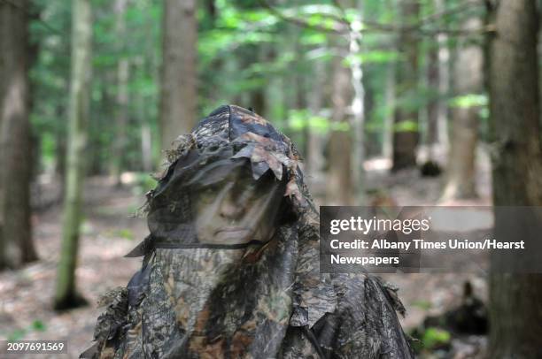 Evan Walsh, associate public health sanitarian for Oswego County Health Department, wears his turkey hunting jacket to protect himself from mosquitos...