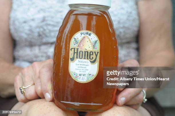Carolyn Wilson holds a jar of the honey that she and her husband, Stephen Wilson, produce on Wednesday, July 3, 2013 in Altamont, NY.