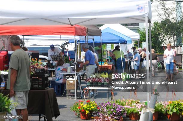 Visitors make their way between the different vendors at the Chicken BBQ and Farmers Market at the First United Methodist Church on Tuesday, June 25,...
