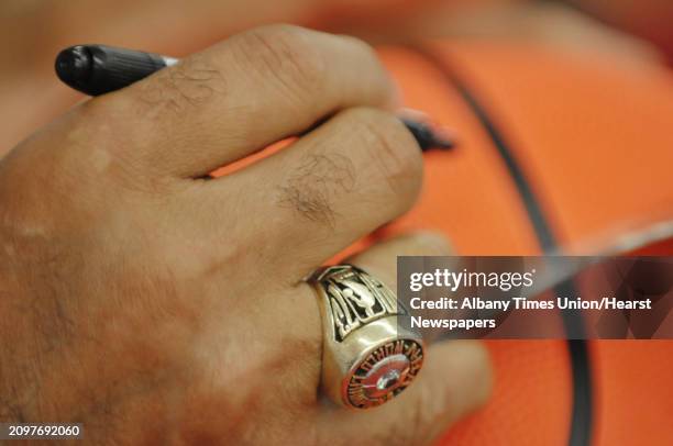 Hall of Famer, Walt "Clyde" Frazier wears his 1973 NBA Championship ring as he signs a basketball for a fan at the grand opening of Ollie's Bargain...