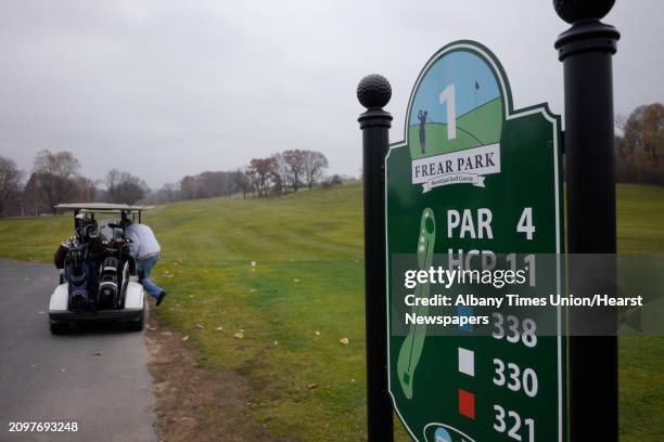 Golfer jumps into his cart to go find his ball after a tee shot at the Frear Park Golf Course on the final day of the season for the course on...