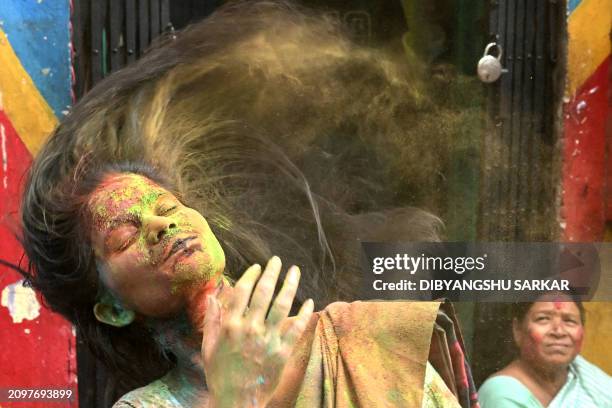 Woman daubed in coloured powders celebrates the Hindu spring festival of 'Holi' during an event organised by the Durbar Mahila Samanwaya Committee, a...