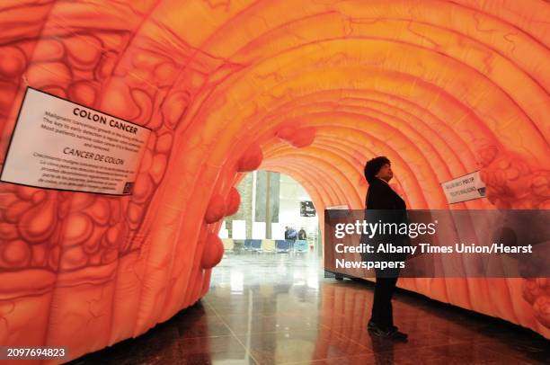 Breast cancer survivor, Yolanda Lee of Albany walks through a large model of a section of a human colon on display in the well of the Legislative...