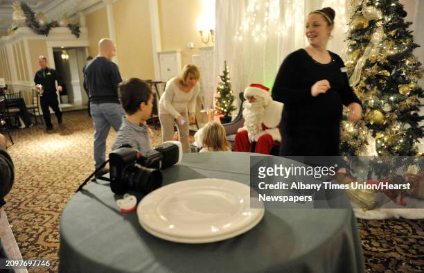 Families gather around Santa to get photos taken during the Brunch with Santa event at Angelo's Tavolo at Glen Sanders Mansion on Sunday, Dec. 21 in...