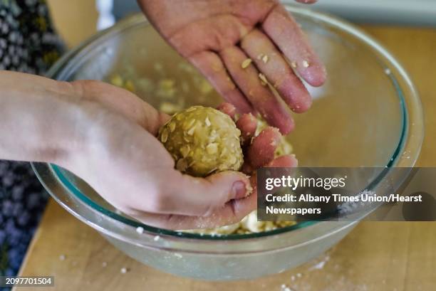 Emily Masters rolls the batter into balls before placing them on a cookie sheet as she makes gluten free brown sugar oatmeal cookies on Monday, April...