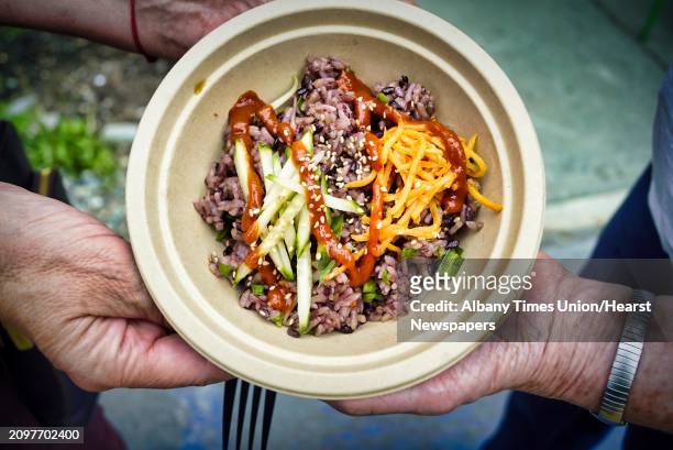 View of the BiBimBop bowl from Sunhee's Farm and Kitchen out of Troy, is shown off by a customer before it is consumed at the Veg Out 2019, hosted by...