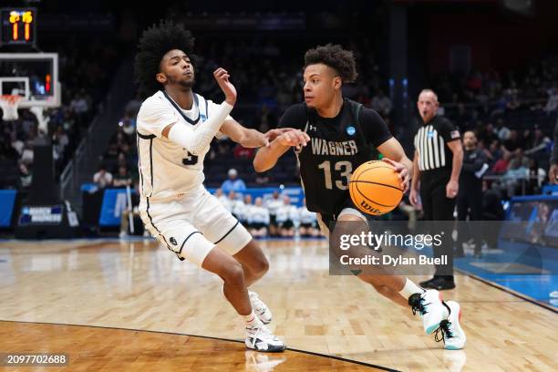 Julian Brown of the Wagner Seahawks drives against Isiah Warfield of the Howard Bison during the first half in the First Four game during the NCAA...