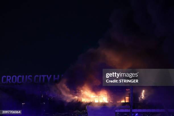 View shows the burning Crocus City Hall concert hall following the shooting incident in Krasnogorsk, outside Moscow, on March 22, 2024. Gunmen opened...