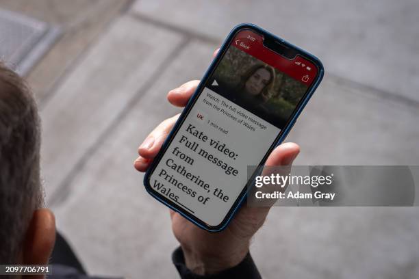 Tristan, from England, listens to the video message by The Princess of Wales on his mobile phone outside of the English restaurant Tea & Sympathy on...