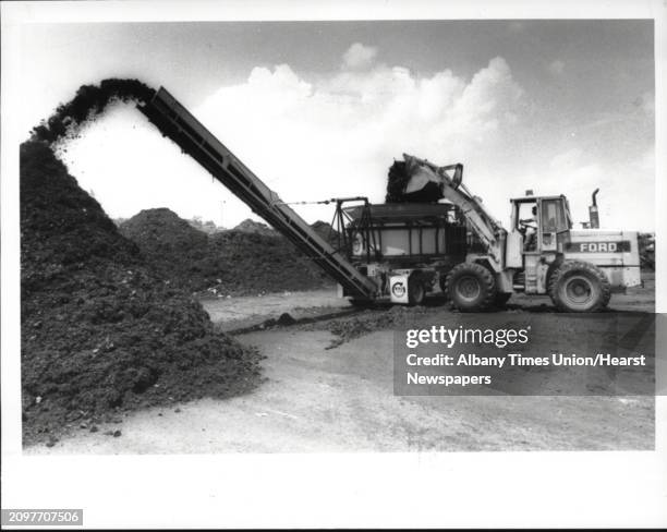 Colonie, New York - landfill - town employees feed grass clippings, etc., into shredder which puts finely ground material into compost piles. June...