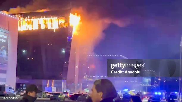 Screen grab from a video shows smoke rises from fire as ambulances, personnel arrive at Crocus City Hall concert venue near Moscow, Russia after...